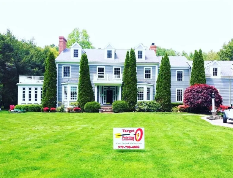Two-storey white colonial repainted, with the Target Painting sign on the lawn