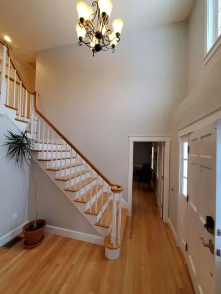 Interior stair hall painted in a warm white with a natural wood handrail