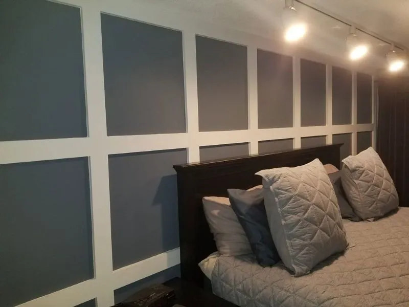 Bedroom feature wall with a dark painted grid of applied moulding
