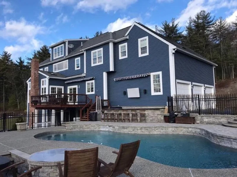 Navy poolside elevation with white trim and a stained deck