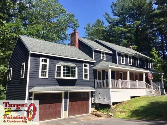 Navy colonial exterior with contrasting garage doors after painting