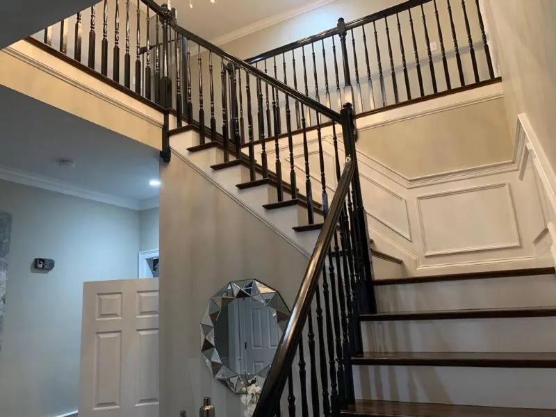 Stairwell with painted wainscoting and black iron balusters