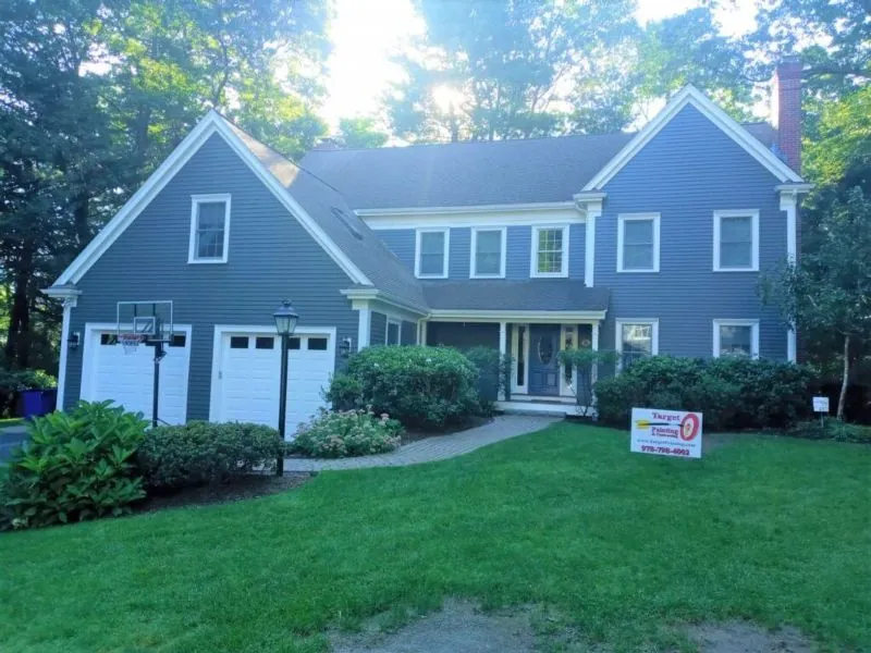 Blue colonial with a two-bay garage after a full repaint