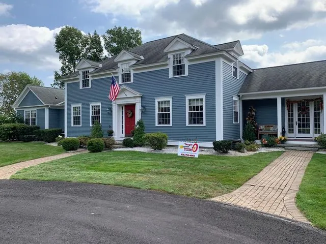 Blue-grey colonial with fresh white trim and a red front door