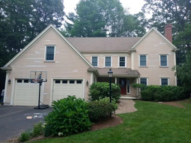 Cream colonial with attached garage and repainted trim
